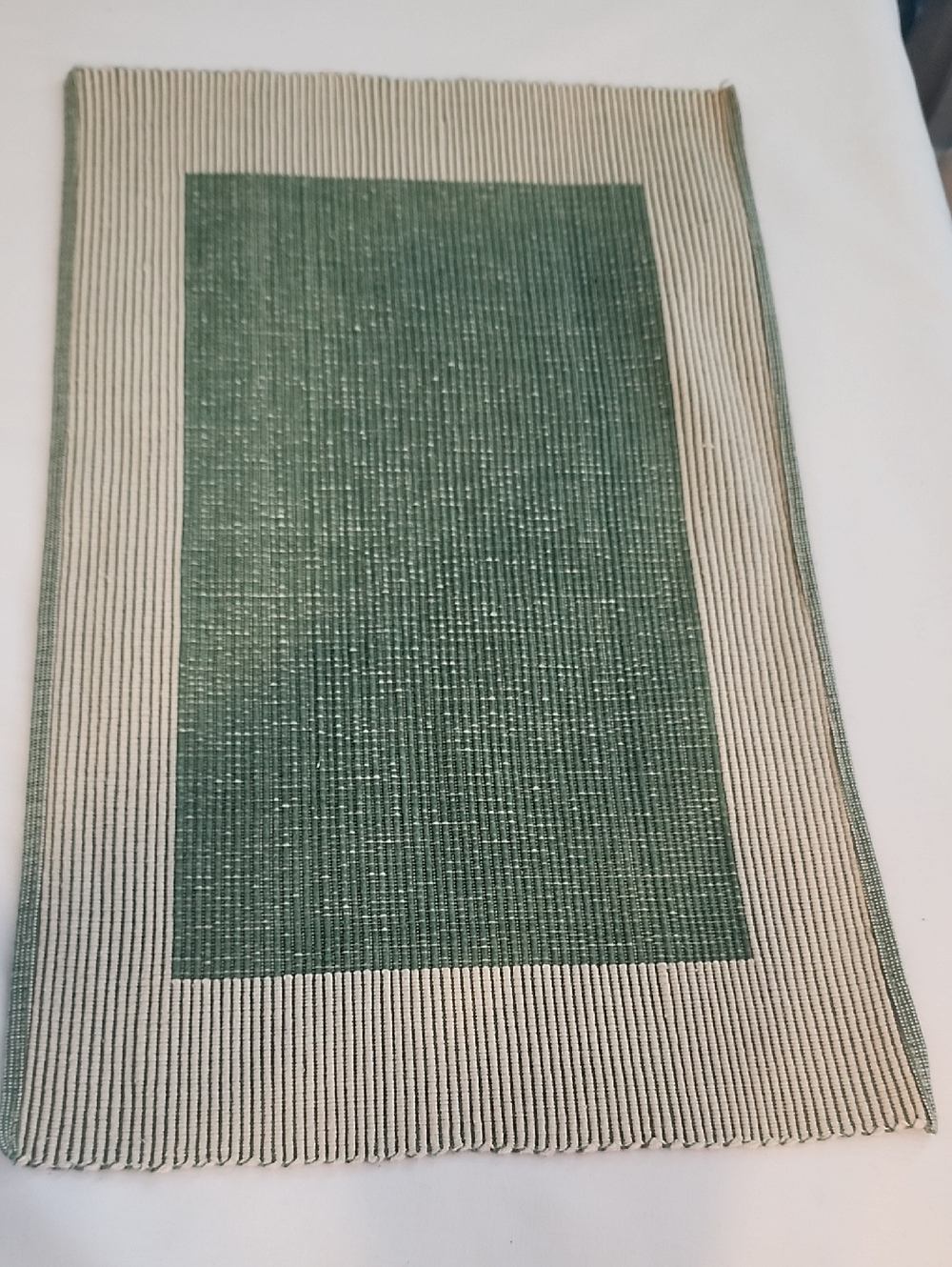 Cost Plus World Market Green and Cream Woven Placemat that have a ribbed texture